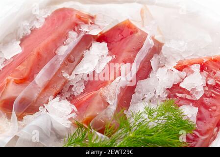 Steak de thon congelé vide avec de la glace sur le comptoir le marché aux poissons. Heurisez le concept alimentaire et nutritionnel Banque D'Images