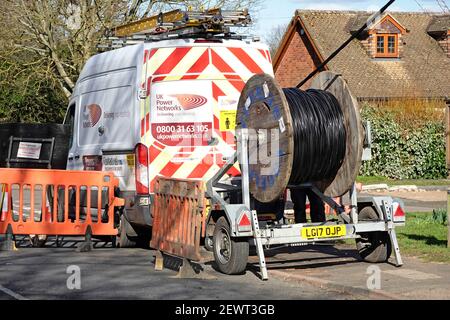 Camion commercial de distribution et remorque à tambour de câblage de UK Power Networks Remplacement des câbles aériens du réseau électrique dans le village d'Essex, Angleterre Banque D'Images