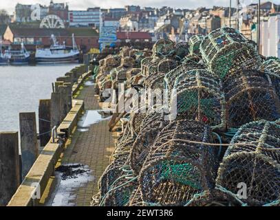 Pots de homard empilés dans un tas sur un port côté quai du port de pêche Banque D'Images