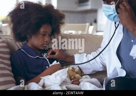 Un médecin afro-américain utilisant un stéthoscope sur un enfant Banque D'Images