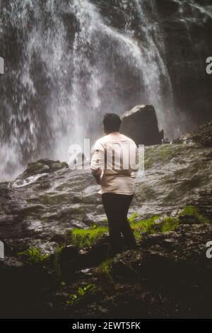 Kookal, Inde - 21 février 2021: L'homme asiatique se tient près des chutes d'eau. Images éditoriales. Banque D'Images