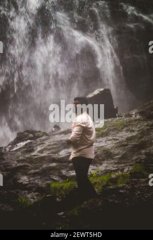 Kookal, Inde - 21 février 2021: L'homme asiatique se tient près des chutes d'eau. Images éditoriales. Banque D'Images