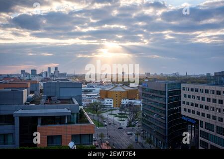 Le soir, des rayons du soleil se font jour à travers les nuages au-dessus de la Potsdamer Platz, Berlin, Allemagne, en avril 2019. Banque D'Images