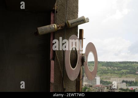 Antenne de signaux TV de bricolage faite avec des canettes de bière et des réflecteurs et installée sur un mur de bâtiment résidentiel, à l'abri des intempéries Banque D'Images