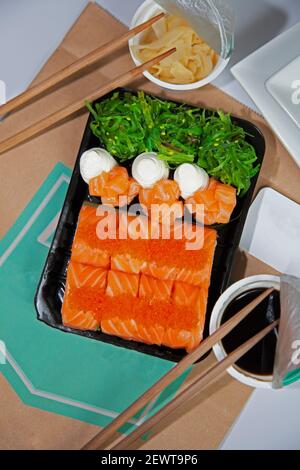 Sushi à emporter. Sauce, gingembre dans des sacs en plastique. Bâtonnets de sushi. Nourriture. Vue de dessus. Philadelphie. Caviar rouge, poissons, algues de mer. Banque D'Images