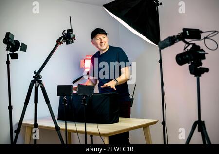 Un créateur de contenu qui se déboîte devant ses caméras et lumières dans son studio Banque D'Images