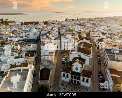 Vue aérienne d'Olhao avec une église en premier plan au coucher du soleil, Algarve, Portugal Banque D'Images