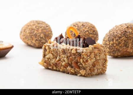 délicieux morceau de gâteau rempli de noix et décoré avec du chocolat à côté de pains de grain entier avec des graines et du sésame sur le dessus, studio Banque D'Images