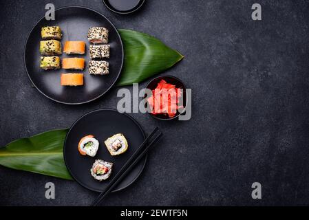 Rouleaux de sushis japonais traditionnels sur fond sombre Banque D'Images