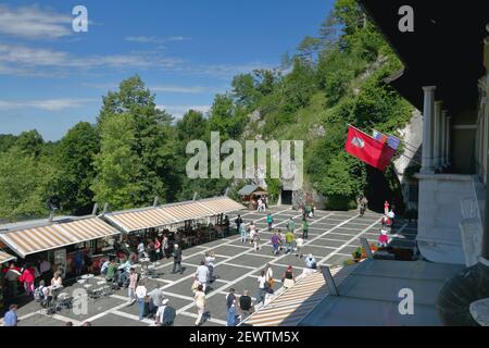 Postojna, Slovénie - 26 juin 2011 : place avec touristes devant l'entrée de la grotte 'Postojnska jama' Banque D'Images