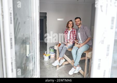 Deux travailleurs souriants portant des échantillons de panneaux de fibres de couleur Banque D'Images