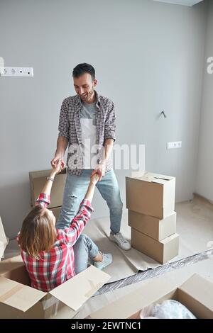 Homme souriant aidant sa femme à se lever Banque D'Images