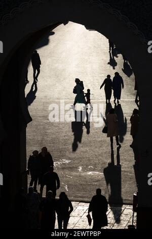 Vue à travers la porte bleue (Bab Bou Jeloud) des piétons jetant de longues ombres sur le sol, Fès, Maroc Banque D'Images