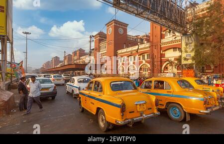 Taxi jaune en file d'attente à la gare de Howrah un point de repère populaire de la ville à Kolkata, Inde au lever du soleil. Banque D'Images