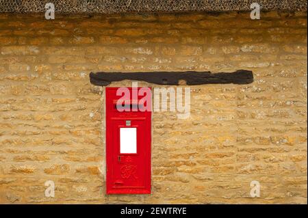 Boîte postale rouge intégrée au mur en grès Banque D'Images