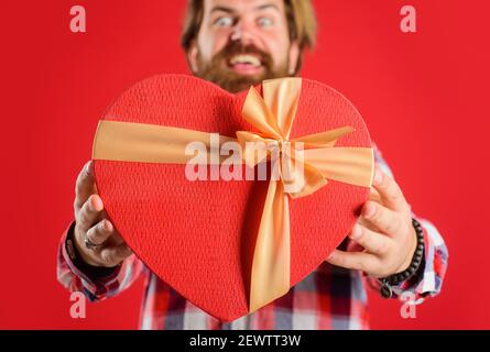 Saint-Valentin. Forme de coeur. Cadeau avec amour. Homme avec cadeau rouge. Joyeuses fêtes. Mise au point sélective. Banque D'Images