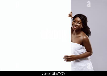 Belle femme noire enveloppée dans serviette après bain tenue blanche Panneau publicitaire Banque D'Images