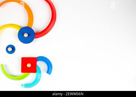 Formes géométriques en bois figurines de jeu colorées composition sur fond blanc. Vue de dessus Banque D'Images