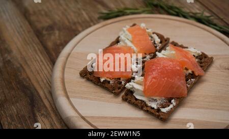 Sandwiches au saumon sur planche à découper en bois Banque D'Images