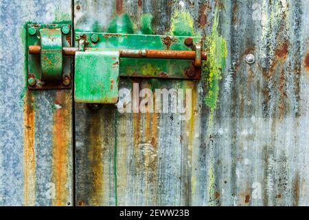 Une serrure verte colorée sur une porte de garage à bateaux dans le comté de Kerry, en Irlande. Banque D'Images