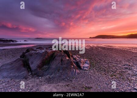 Un coucher de soleil vivivivid sur la plage d'Owenahincha, près du village de Rosscarbery à West Cork, en Irlande, sur la voie de l'Atlantique sauvage. Banque D'Images