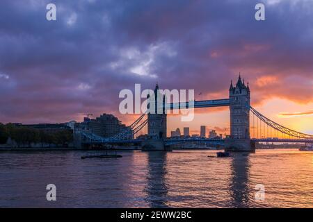 Le Tower Bridge de Londres illuminé par un lever de soleil enflammé, avec Canary Wharf en arrière-plan Banque D'Images