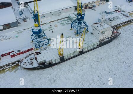 Arkhangelsk, Russie - 18 février 2021 : le navire à l'amarrage dans le port en hiver. Le navire est chargé dans le port. Banque D'Images