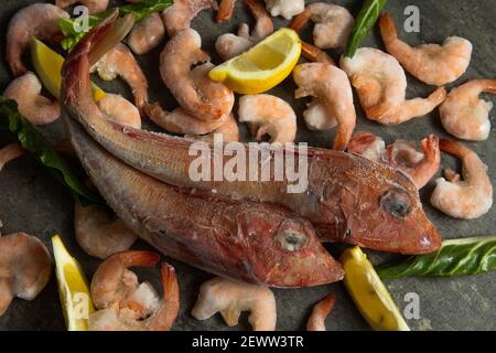 fond carré de nourriture - crevettes rouges cuites congelées et poisson gros plan Banque D'Images