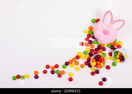 Easter concept, bonbons pilules, oeuf, tête de lapin rose jouet sur fond blanc. Placer pour le texte Banque D'Images