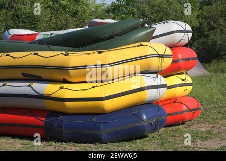 Bateaux de rafting multicolores empilés les uns sur les autres. Banque D'Images