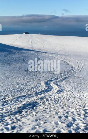 Empreintes de pieds dans le paysage enneigé du sentier de randonnée de Fimmvoerduhal en début de matinée, dans les hauts plateaux de l'Islande Banque D'Images