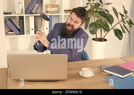 Crier. Résoudre certains problèmes d'affaires. Ordinateur est à la traîne. Homme d'affaires ou Manager en colère avec un marteau à traîner. Homme d'affaires agressif au bureau. Raisons du retard de l'ordinateur. Routine de bureau de haine. Banque D'Images