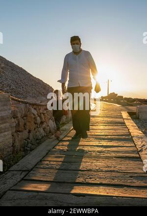 Kahta, Adiyaman, Turquie - septembre 14 2020: Père touristique et sa fille marchant sur le sentier autour de la montagne Nemrut et coucher de soleil en arrière-plan. Banque D'Images