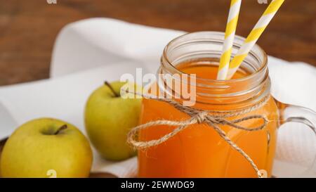 Jus de pomme et de carotte en verre, légumes frais et fruits sur fond de bois. Style rustique. Boisson maison avec vitamines Banque D'Images