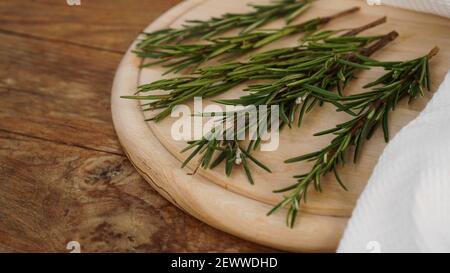Brins de romarin sur une planche en bois pour la coupe. Style rustique. Épice Banque D'Images
