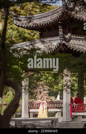 Huzhou, Chine, 18 novembre 2020: Femme chinoise portant une robe traditionnelle et tenant un fan dans le parc en Chine. Happy Spring Festival, nouvel an chinois Banque D'Images