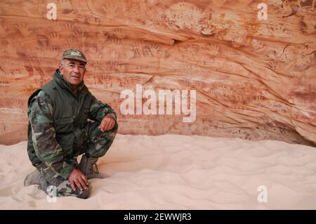 L'explorateur Ahmed Mestikawi se trouve sur le site d'art rupestre et de peinture néolithique de la grotte Foggini-Mestikawi à Wadi Sura, Gilf Kebir, dans le désert occidental en Égypte. Banque D'Images