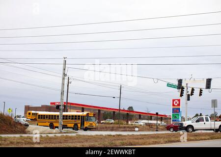 Richmond County, GA USA - 03 03 21: Vue sur la rue des voitures d'autobus scolaires et du panneau de prix de l'essence Circle K. Banque D'Images