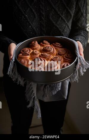 Vue céniale des petits pains à la cannelle fraîchement sortis du four sur fond coloré, Banque D'Images