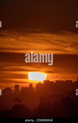 Un soleil orange spectaculaire se couche sur la ligne d'horizon du côté ouest de Los Angeles. Banque D'Images