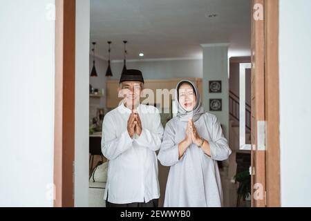 portrait d'un couple asiatique musulman debout devant la porte d'entrée attendre que la famille vienne Banque D'Images