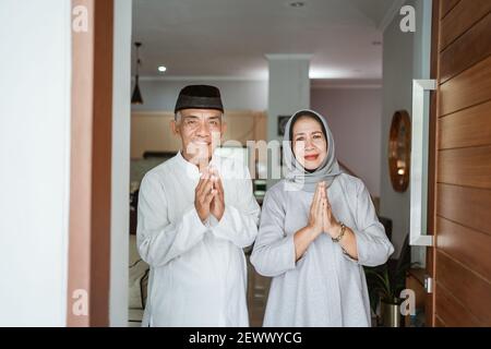 portrait d'un couple asiatique musulman debout devant la porte d'entrée attendre que la famille vienne Banque D'Images