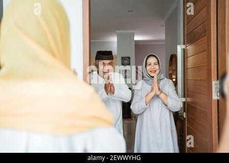 portrait d'un couple asiatique musulman debout devant la porte d'entrée attendre que la famille vienne Banque D'Images