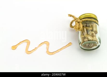 Gros plan de la courbe en spirale du gel et de la pilule orange isolés sur fond blanc. Banque D'Images