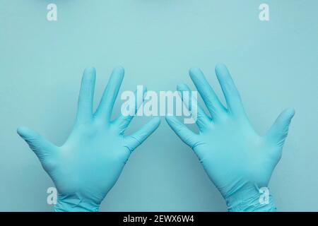 Main de médecin portant une paire de gants chirurgicaux de protection bleus. Banque D'Images
