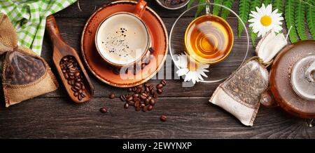 Tisane dans la théière et la tasse, café expresso et haricots rôtis sur une table en bois. Plan d'étapage avec vue de dessus Banque D'Images