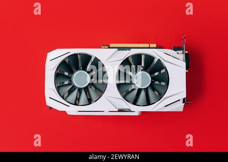 La carte graphique blanche avec deux ventilateurs noirs est située au milieu de l'arrière-plan rouge. Périphériques informatiques tendance Banque D'Images