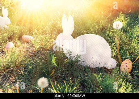 Le concept des vacances de Pâques. Artisanat décoratif produit artisanal sous forme de lapin blanc couché, situé à côté des œufs peints. Dans le b Banque D'Images