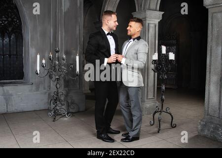 Jeune heureux gay couple se marient dans l'église. Amour et romance. Des hommes séduits en costume. Banque D'Images