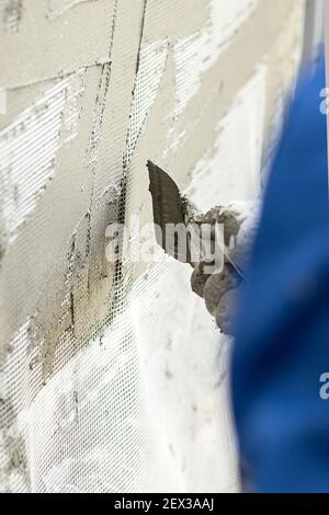 Travailler avec une spatule, la préparation des murs pour carrelage. Façade humide de la technologie. Banque D'Images